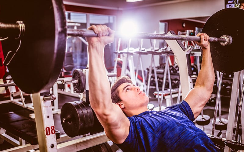 Fit man doing incline bench press in the gym