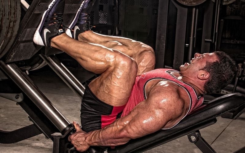 Muscular man doing leg press.