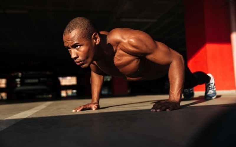 Shirtless muscular man doing pushups.