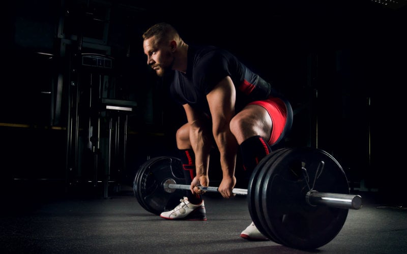 Powerlifter doing deadlifts in gym.