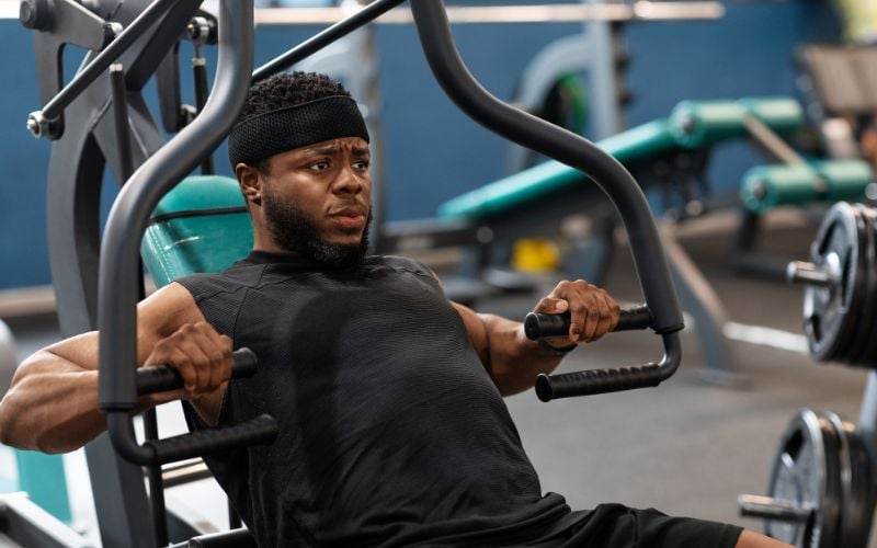Muscular african american man doing a chest workout at the gym.