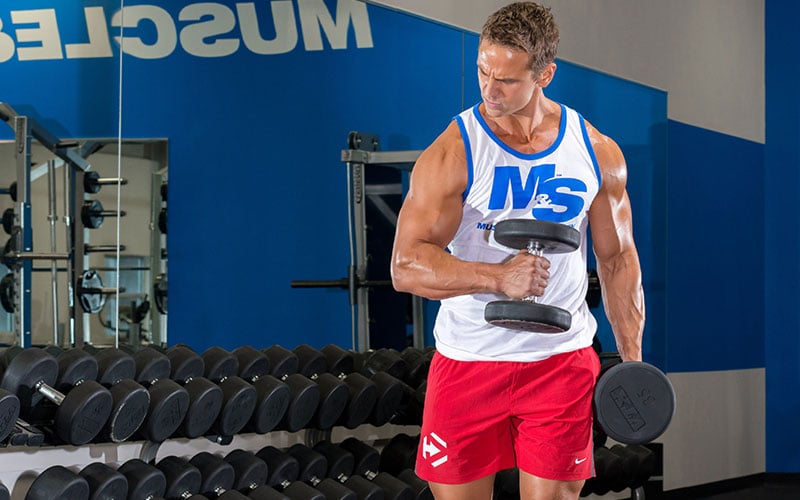 Dymatize Athlete Flexing his tricep while working biceps