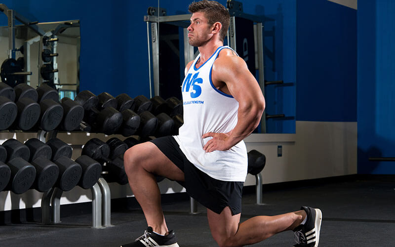 Male athlete performing forward lunges despite knee pain
