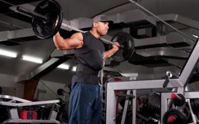 Man standing in the gym with barbell on shoulders