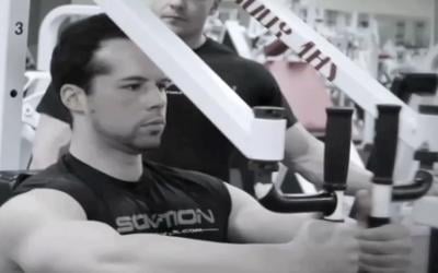 Bodybuilder doing machine flys in the gym