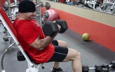 Bodybuilder doing a curl in the gym