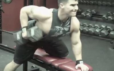 Young bodybuilder doing dumbbell row in the gym