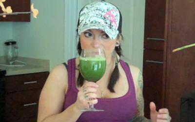 Fit woman with smoothie in the kitchen