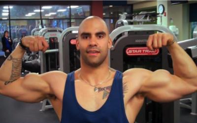 RJ Perkins flexing biceps in the gym