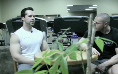 2 bodybuilders sitting at a high table talking