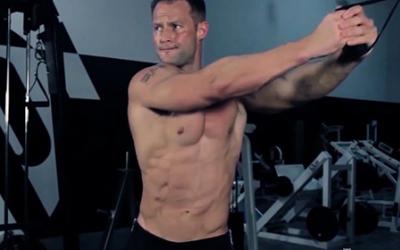 Shirtless bodybuilder working out in the gym