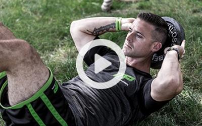 Man doing kettlebell crunches outside