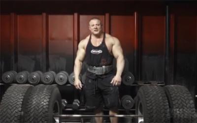 Strongman Matt Kroc standing in from of tire deadlift