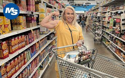 IFBB Figure Pro Samantha Jerring flexing in the grocery shopping aisle.