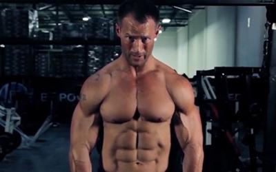 Man standing in the gym with abs shirt off