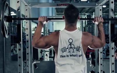 Big man doing barbell shoulder press in the gym