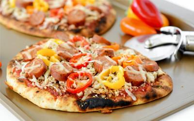 Close up of oven roasted flat bread pizza topped with pizza sauce, shredded cheese, peppers, and sausage.