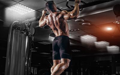 Muscular man doing wide grip pull-up's in the gym.