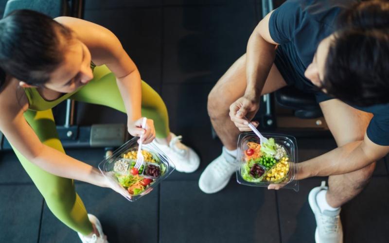 Aerial view of a fit man and woman eating healthy in the gym.
