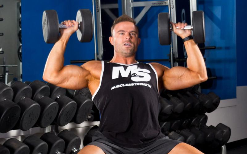 M&S model doing seated dumbbell shoulder press. 