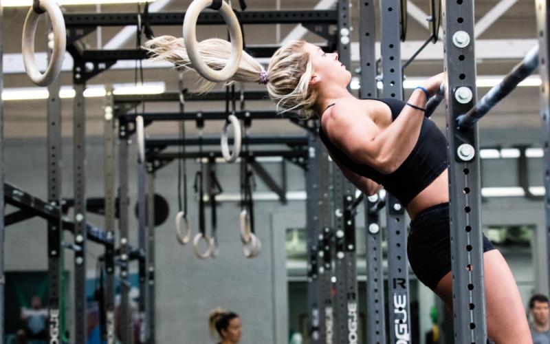 Swolverine athlete doing butterfly kipping chest to bar.