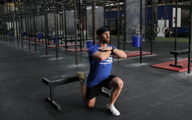 Fit man doing a bodyweight bulgarian split squat in the gym.