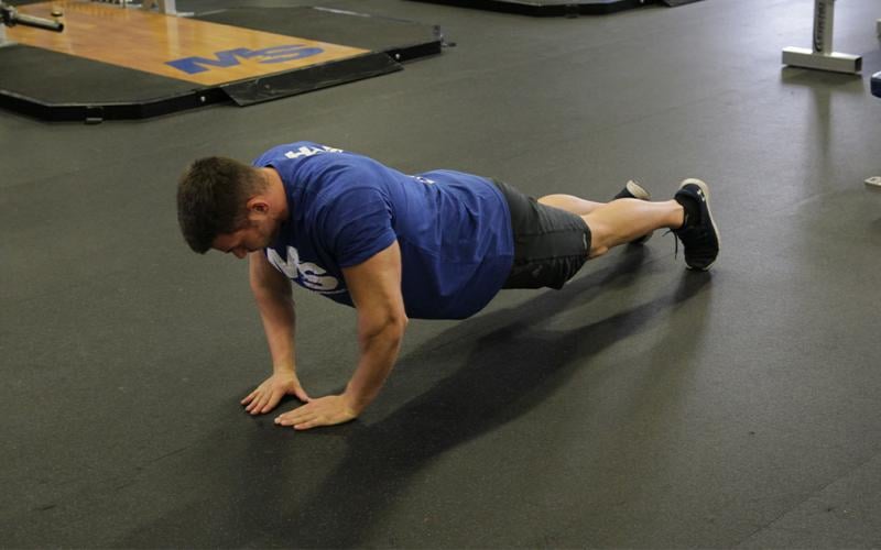 Fit man doing a close grip push up in the gym.