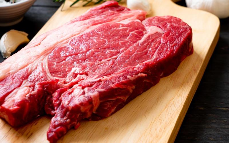 Close up shot of deer meat on a wooden cutting board.