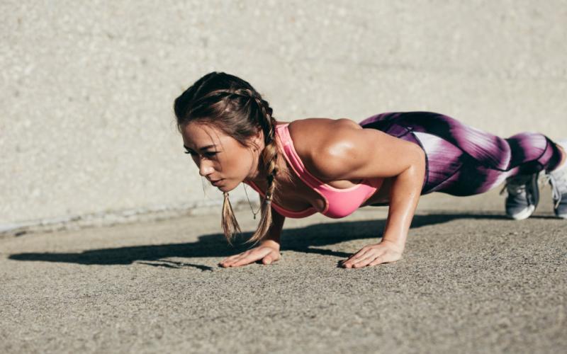 Woman doing pushups outside.