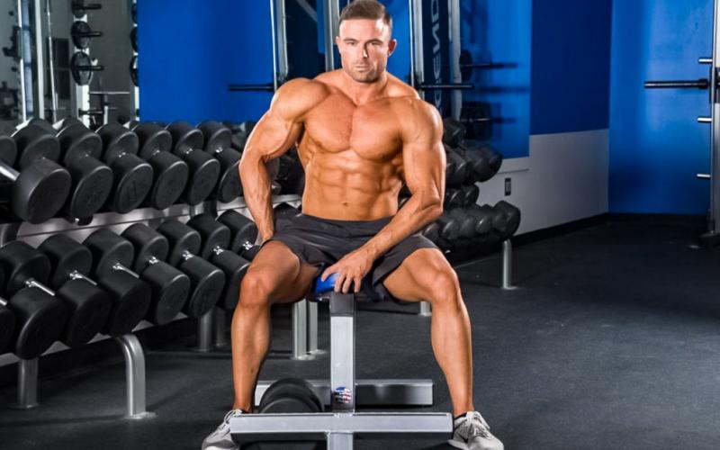 Bodybuilder sitting on a bench in the gym