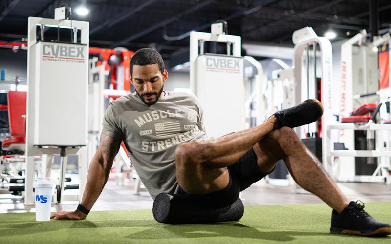 Fit man foam rolling in the gym.