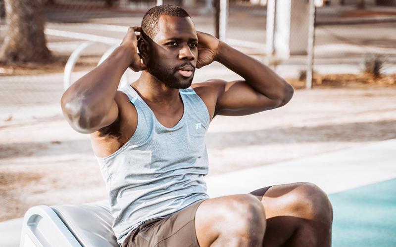 Man doing ab crunches outside.