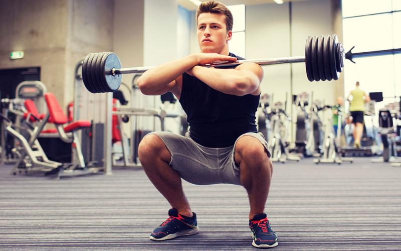 Muscular man doing front squat in the gym