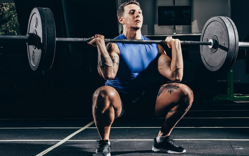 Muscular man doing barbell front squat