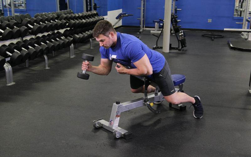 Fit man doing a one-arm prone hammer curl 