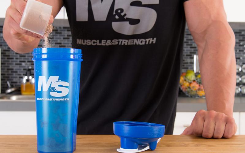 Pouring whey protein into shaker cup