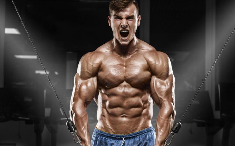 Muscular man doing cable crossover machine.