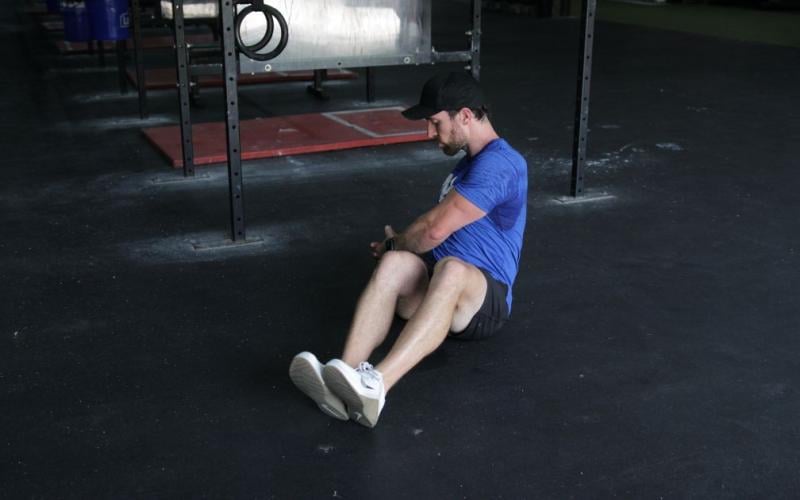 Fit man doing russian twists in the gym.