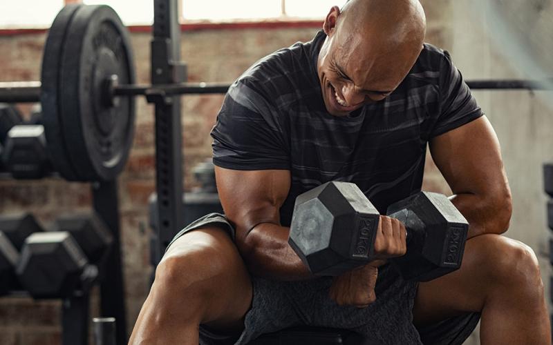 Strong man doing dumbbell curl