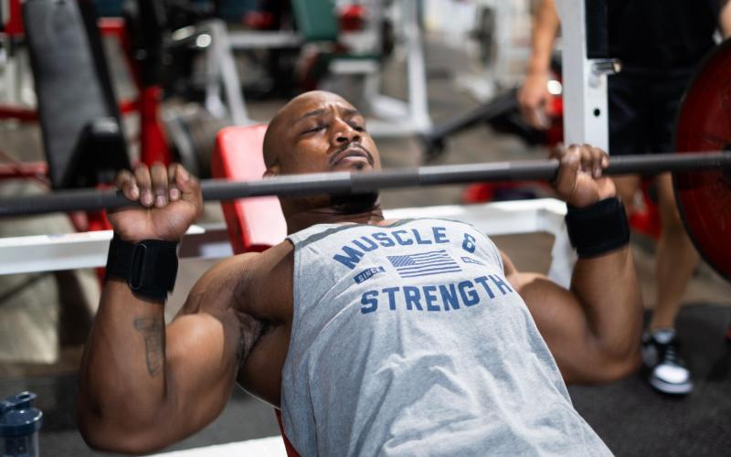Strong man doing heavy bench press in the gym.