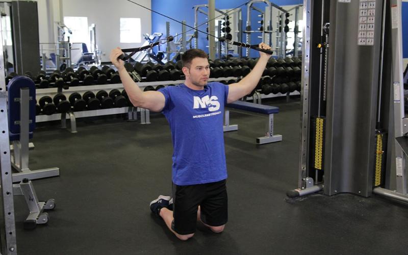 Fit man doing a two-arm tricep cable extension