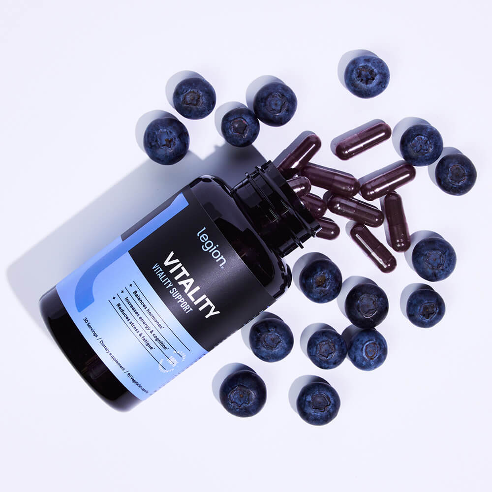 Legion Vitality Vitality Support capsules and bottle surrounded by fresh blueberries