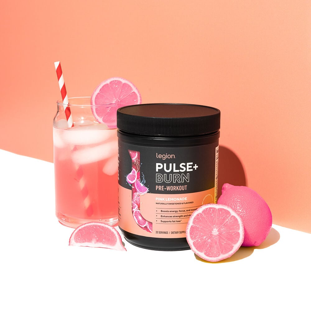 Pulse+ Burn Pink Lemonade pre-workout tub with a glass of iced pink lemonade and pink lemons